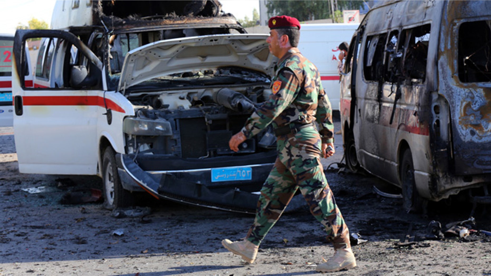 Sept. 29, 2013: A Kurdish policeman passes by destroyed ambulances at the site of a car bomb attack in front of the main security forces headquarters in Irbil, Iraq, 217 miles north of Baghdad. A twin suicide car bombing and ensuing firefight in the capital of Iraq's largely peaceful self-ruled northern Kurdish region killed and wounded dozens of security forces on Sunday, officials said.