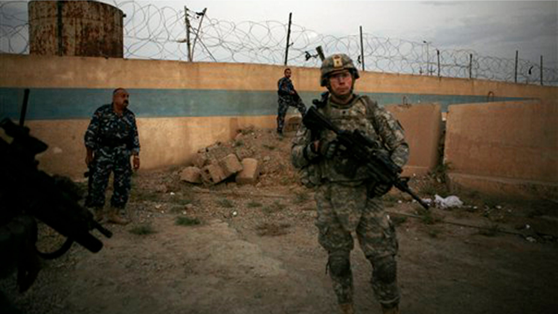 A U.S. Army soldier from 1st Battalion, 14th Infantry Regiment stands with Iraqi policemen outside an Iraqi police station Sept. 1 in Hawija, north of Baghdad, Iraq. (AP Photo)