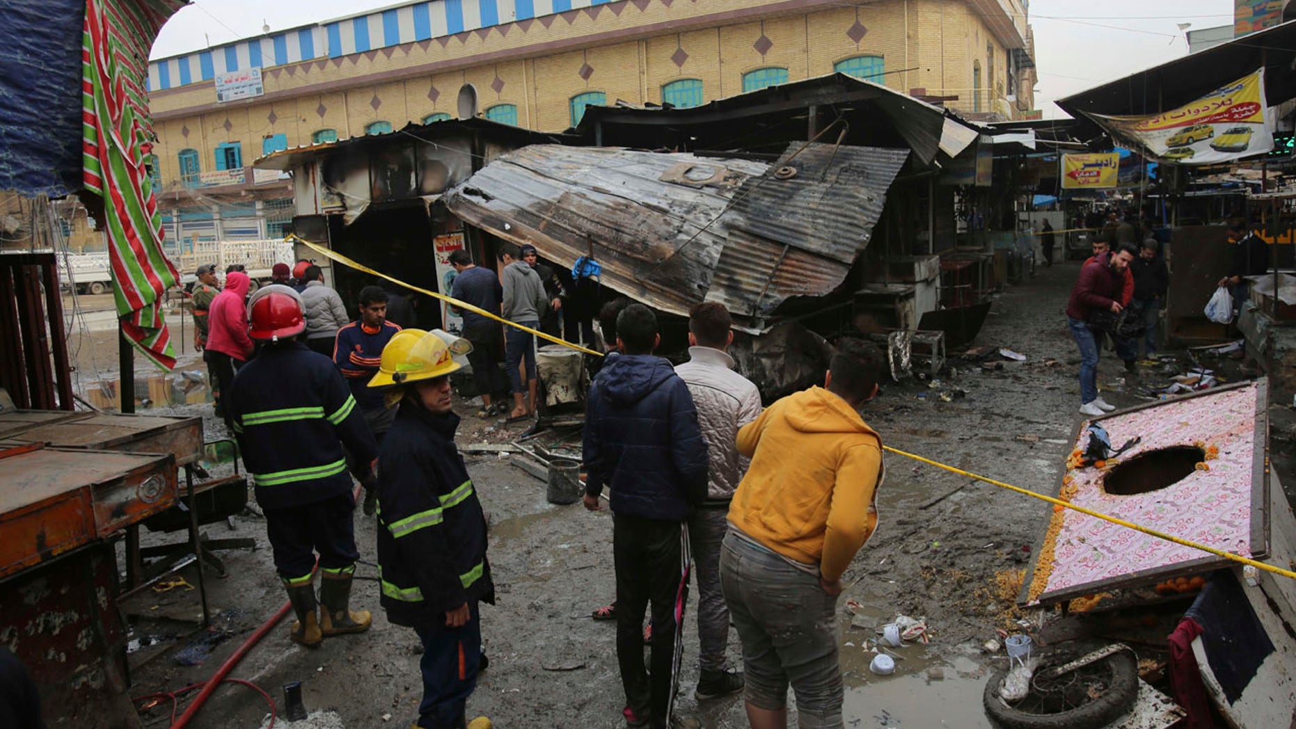 Iraqi people gather at the site of bomb attack in a busy market area in Baghdad's central al-Sinek neighborhood, Iraq, Saturday, Dec 31, 2016. (AP Photo/ Karim Kadim)