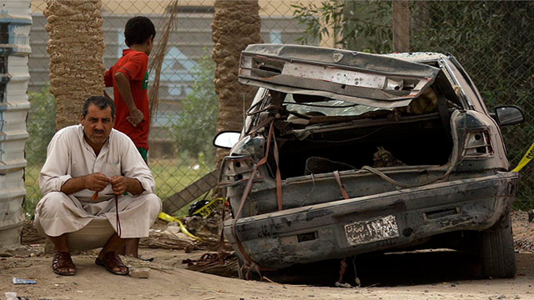 Oct. 1: A man sits next to his damaged car at the scene of a car bomb attack in a town just outside Hillah, about 60 miles south of Baghdad, Iraq.
