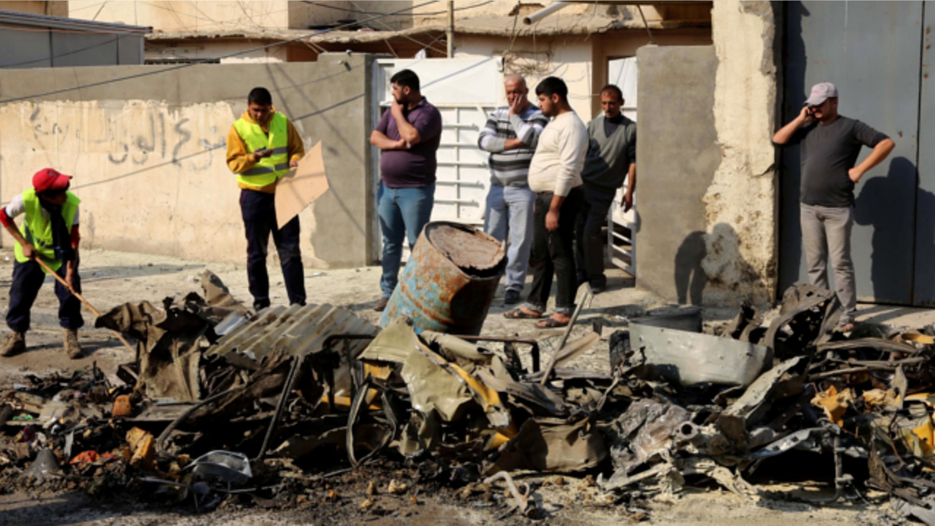 Jan. 15, 2014: Baghdad municipality workers clean up as civilians inspect the site of a car bomb attack near the Technology University in Sinaa Street in downtown Baghdad, Iraq.