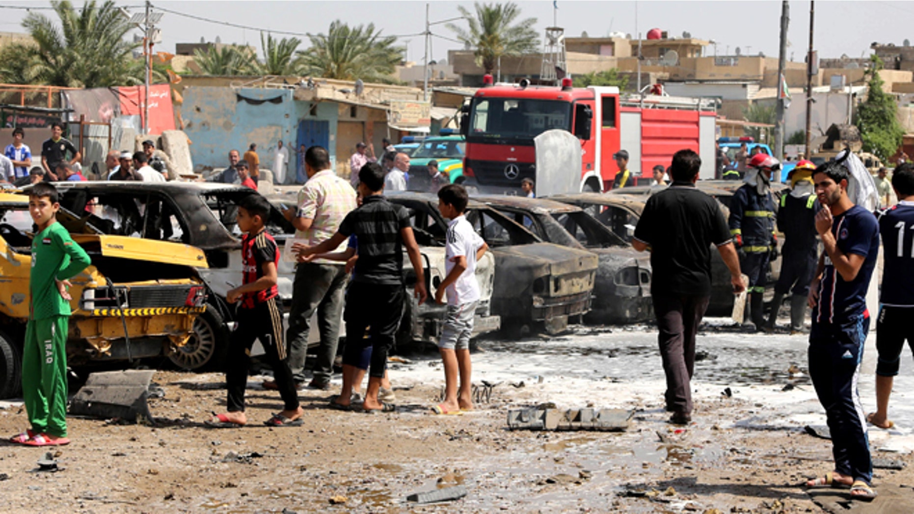 May 13, 2014: Civilians inspect the site of a car bomb explosion in the Shiite stronghold of Sadr City, in Baghdad, Iraq. (AP)