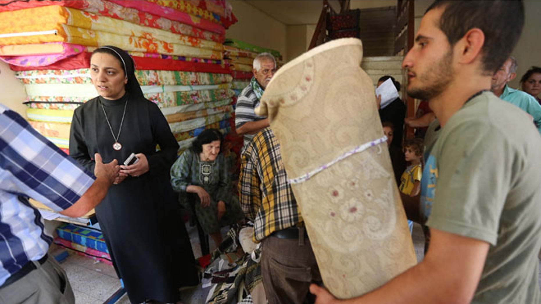 June 27, 2014: An Iraqi nun, second from left, speaks with a Christian man who fled with his family from the Christian villages near Mosul, Iraq, at a school that was turned into a shelter for displaced Christian families, in Ainkawa, a suburb of Irbil, Iraq.