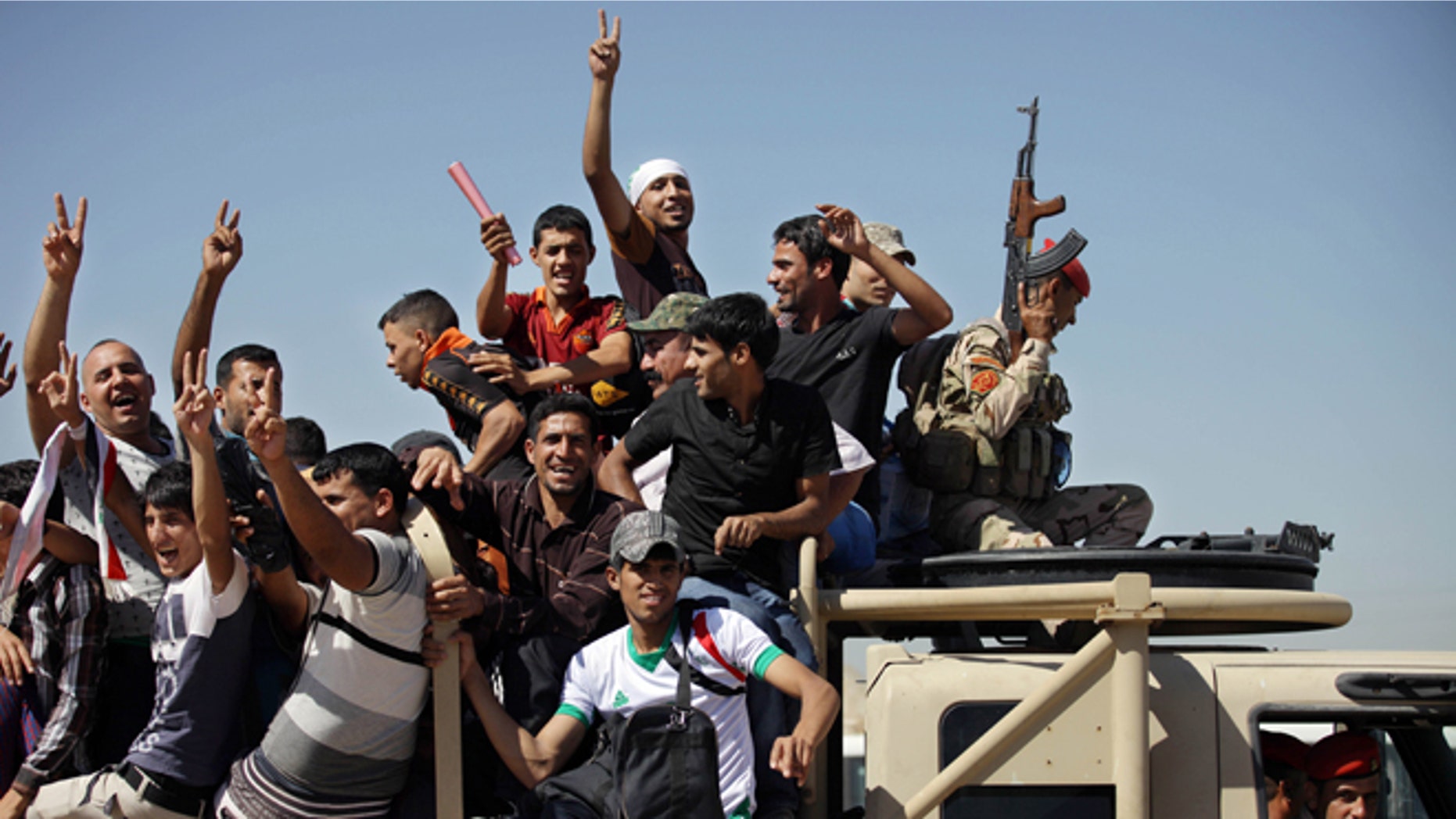 June 17, 2014: Iraqi men flash victory signs as they leave the main recruiting center to join the Iraqi army in Baghdad, Iraq, after authorities urged Iraqis to help battle insurgents. (AP)