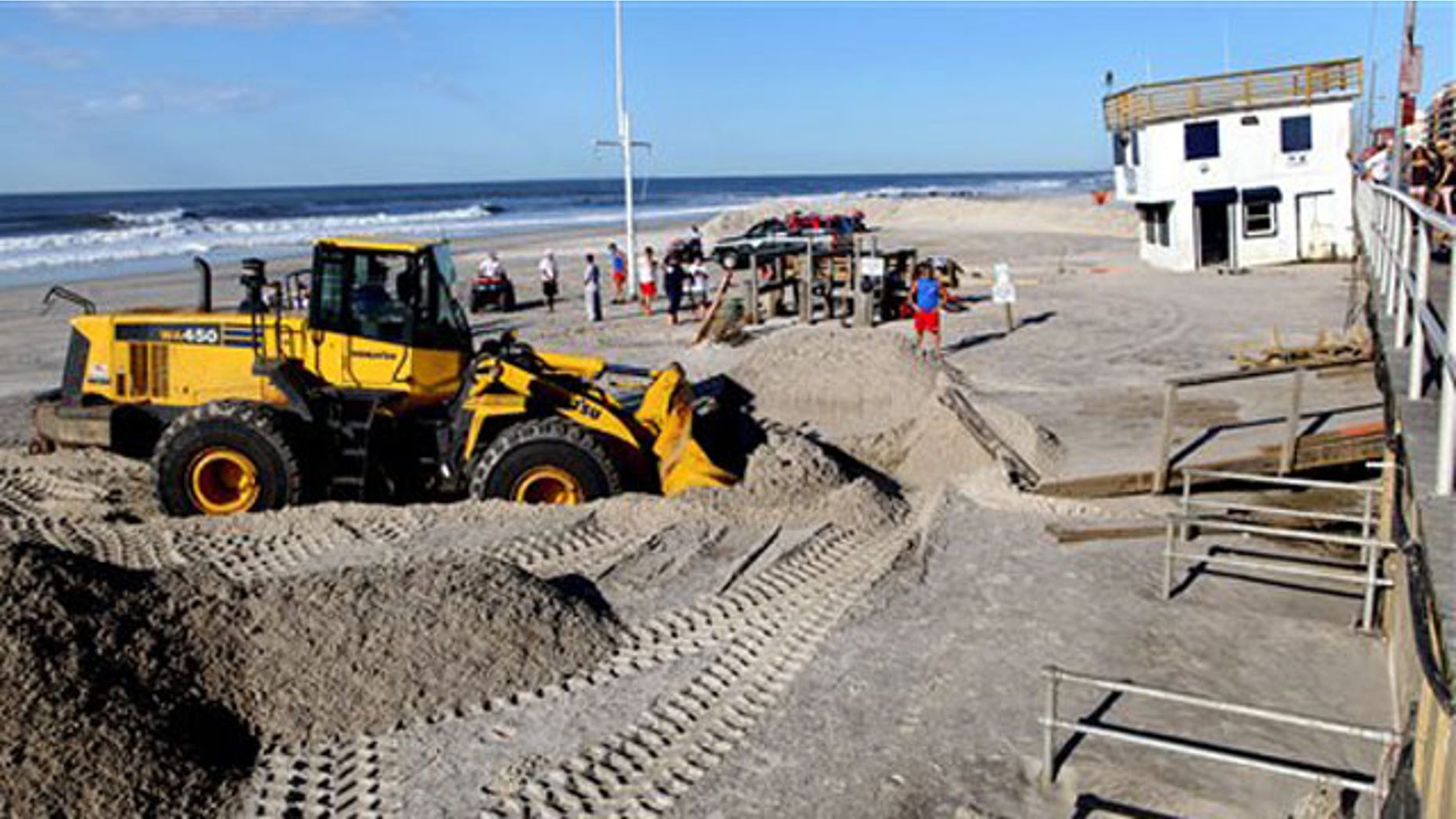 Cleanup continues near a dislodged lifeguard shack, now against the boardwalk in Long Beach, N.Y. Monday, Aug. 29, 2011, after it was knocked off its footing on the beach during Tropical Storm Irene Sunday in Long Beach, N.Y. (AP Photo/Craig Ruttle)