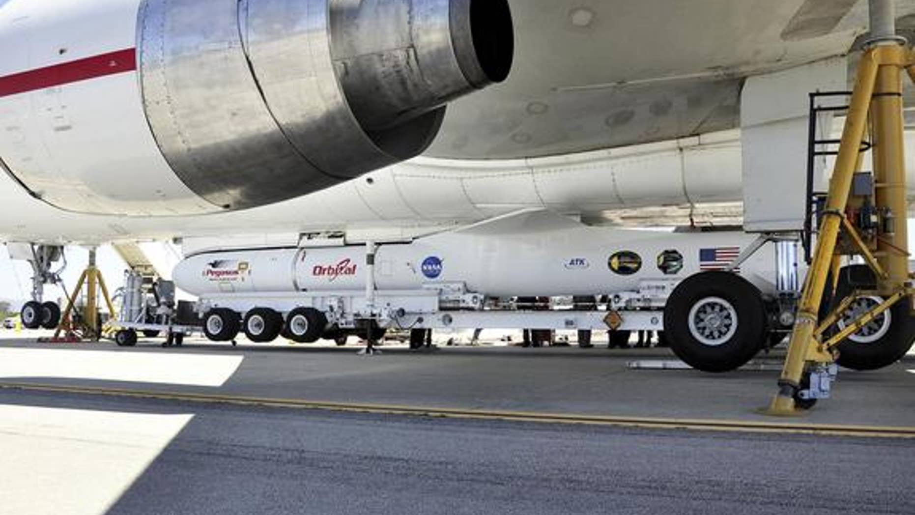 This image shows technicians and engineers at Vandenberg Air Force Base in California connecting the Pegasus XL rocket with the Interface Region Imaging Spectrograph, or IRIS, solar observatory to the Orbital Sciences L-1011 carrier aircraft.