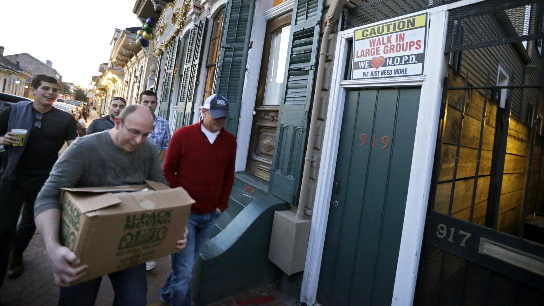 Jan. 18, 2015: Men walk past a sign encouraging people to walk in large groups, in the French Quarter of New Orleans.