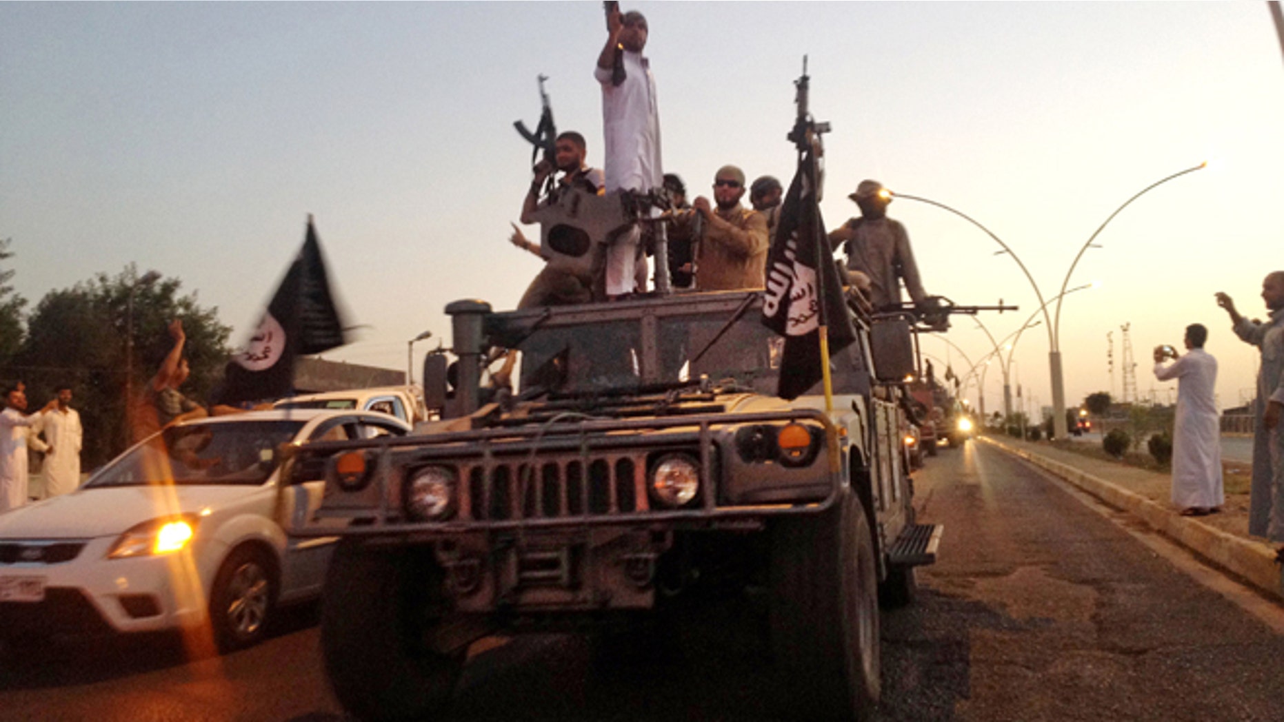 June 23, 2014: Militants from the Islamic State parade in a commandeered Iraqi security forces armored vehicle on a main street in Mosul, Iraq. The Islamic state group has accelerated killings of former policemen and army officers, apparently fearing they might join a potential internal Sunni uprising against its rule.