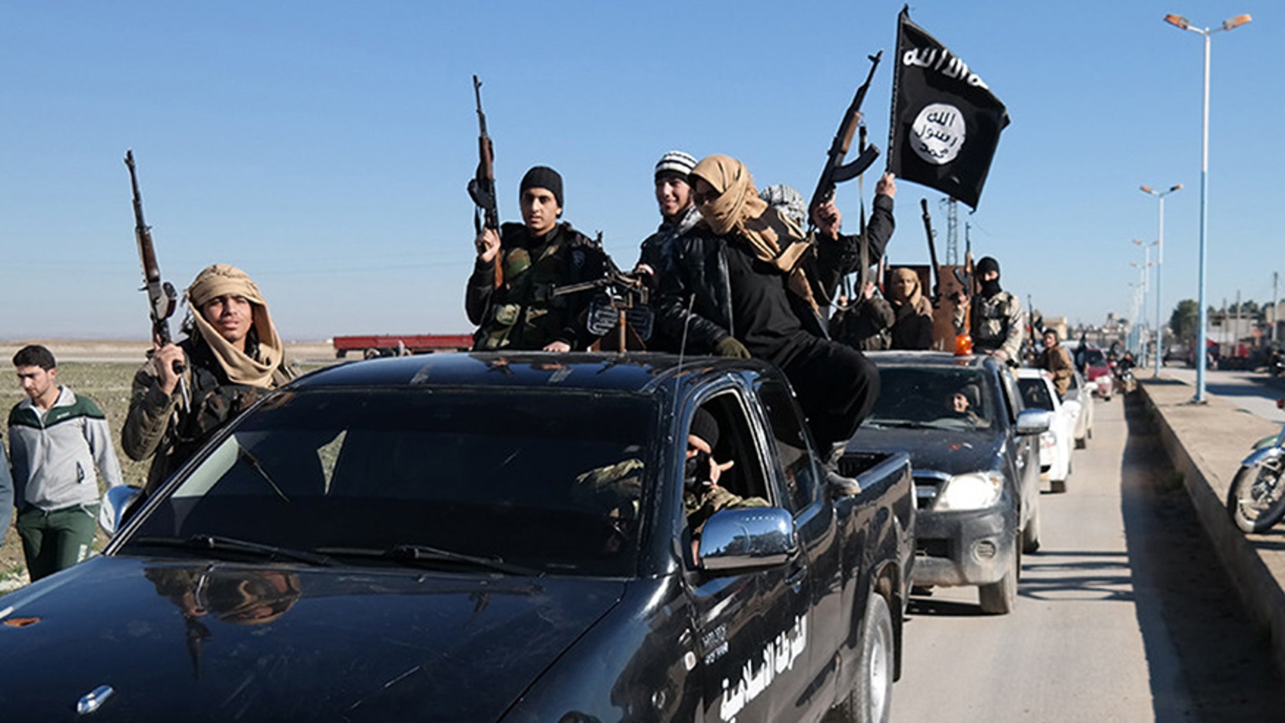 May 4, 2015: In this this file photo released on a militant website, which has been verified and is consistent with other AP reporting, Islamic State militants pass by a convoy in Tel Abyad, northeast Syria.