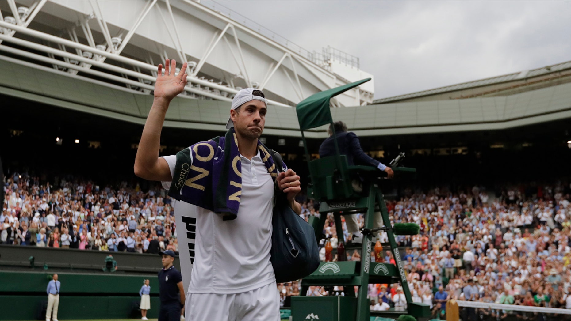 John Isner of the U.S. leaves the court after being defeated by Kevin Anderson of South Africa in the men's semifinal match at Wimbledon on Friday. It was a marathon game.