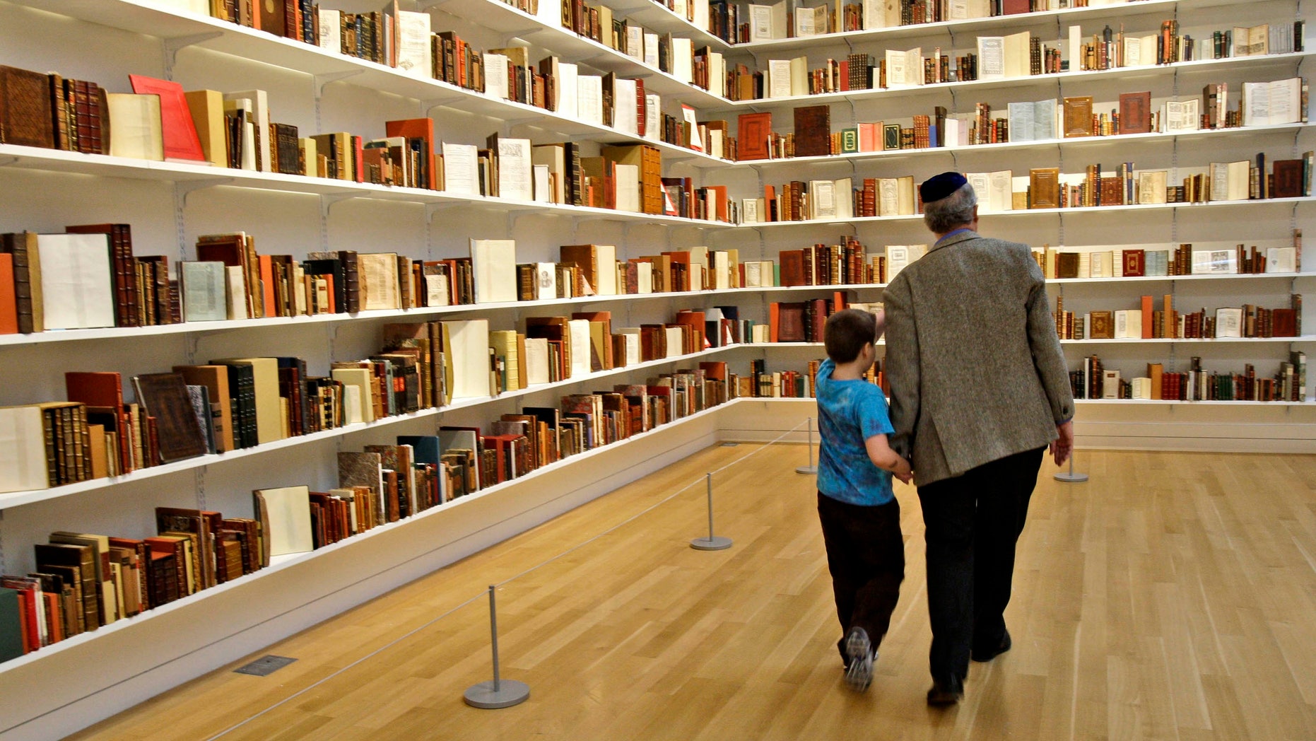 FILE - In this Monday, Feb. 9, 2009 file photo, Benjamin Zucker, an author and precious stones specialist, and his grandson Abram Goren, 8, visit The Valmadonna Library Trust collection on display at Sotheby's in New York,The National Library of Israel said Thursday it has acquired what is considered the world's greatest private collection of Hebrew books and manuscripts. (AP Photo/Kathy Willens)