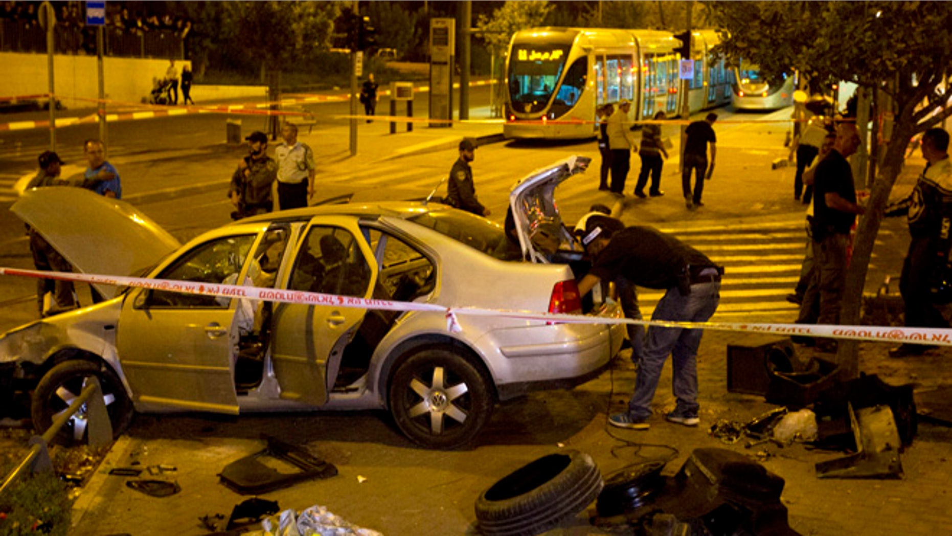 Oct. 22, 2014: Israeli police officers inspect a car at the scene of an attack in Jerusalem. A Palestinian motorist with a history of anti-Israel violence slammed his car into a crowded train station in Jerusalem on Wednesday, killing a three-month-old baby girl and wounding several people in what police called a terror attack.