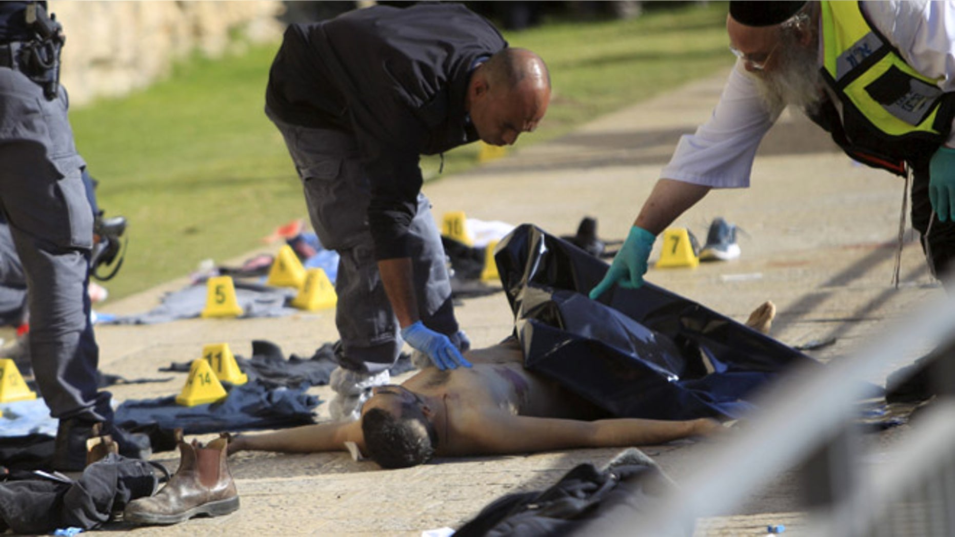 Dec. 23, 2015: An Israeli forensic policeman and an emergency service employee work next to the body of a Palestinian, who was shot dead by Israeli police after he went on a stabbing spree along with another Palestinian man, wounding at least three people, in what authorities called a terrorist attack, near Jaffa Gate in Jerusalem's Old City. (Reuters)
