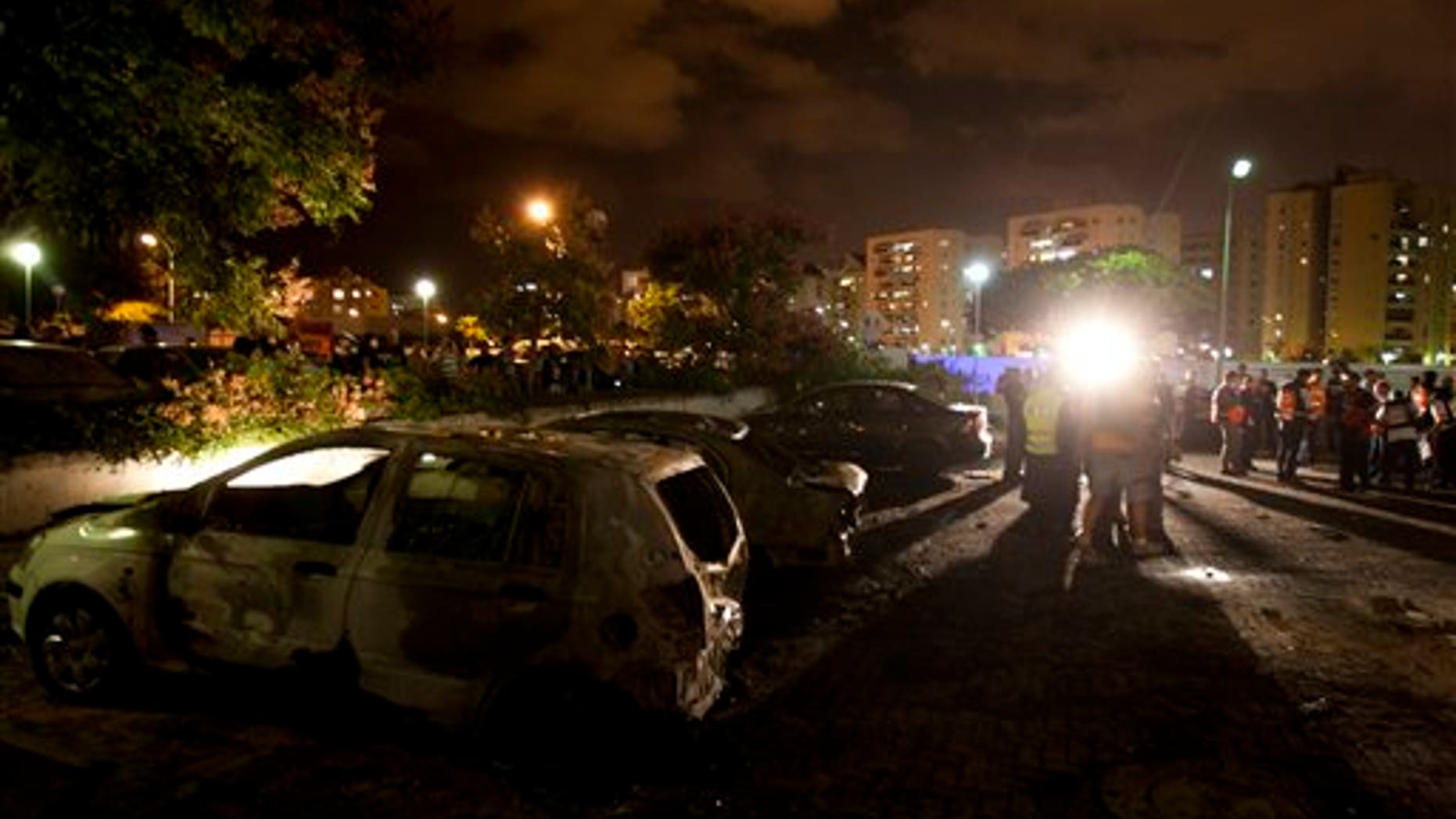 Oct. 29, 2011: Israeli paramedics and security officers work next to destroyed cars at a site where a rocket fired from the Gaza Strip hit in Ashdod, southern Israel. Israeli aircraft struck at Palestinian militants on Saturday, killing five, while militants responded with a volley of rockets which injured several Israeli civilians, Israeli and Palestinian officials said.