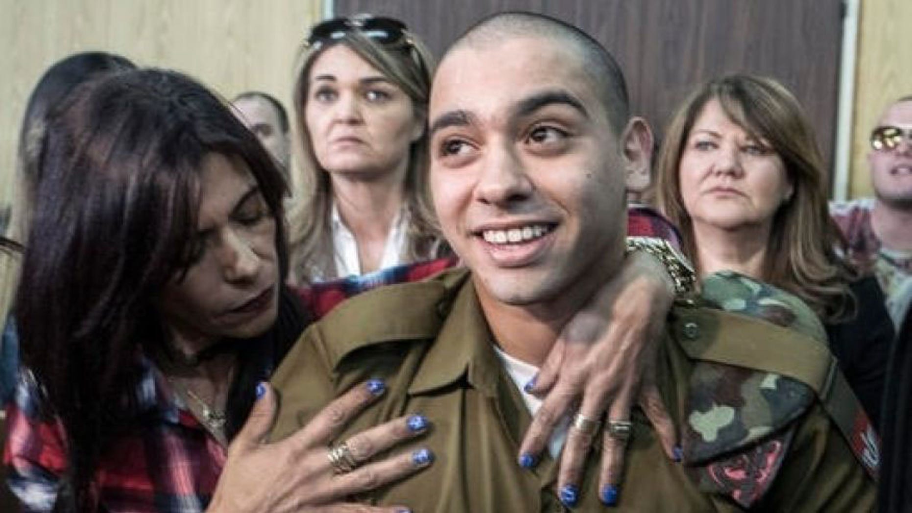 Elor Azaria embraced by his mother at the start of his sentencing hearing.