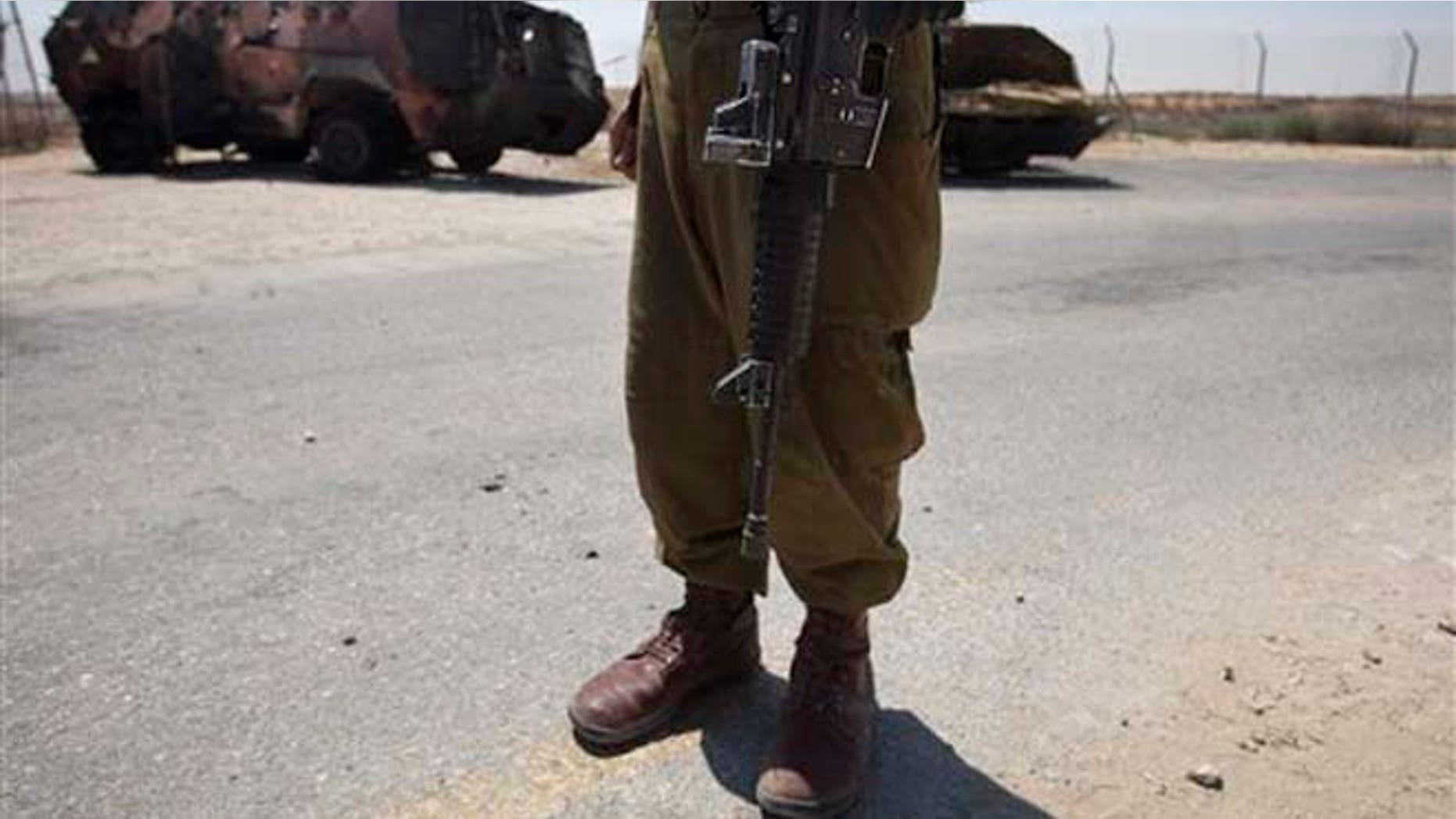 An Israeli soldier examines the wreckage of an Egyptian military vehicle after militants burst it through a security fence into Israel from Egypt, at an Israeli military base along the border with Egypt, southern Israel, Monday, Aug. 6, 2012. Masked gunmen killed scores of Egyptian soldiers Sunday, Aug. 5, 2012, at a checkpoint along the border with Gaza and Israel, the first such attack on troops and then the attackers drove off, crashing into Israel, officials said. Egypt blamed Islamist militants from Gaza and Egypt's troubled Sinai Peninsula. President Mohammed Morsi said the attackers "will pay dearly." The Israeli military said the attack was part of a plot to abduct an Israeli soldier, and two vehicles commandeered by the attackers crashed into Israel, where one blew up. (AP Photo/Ariel Schalit)