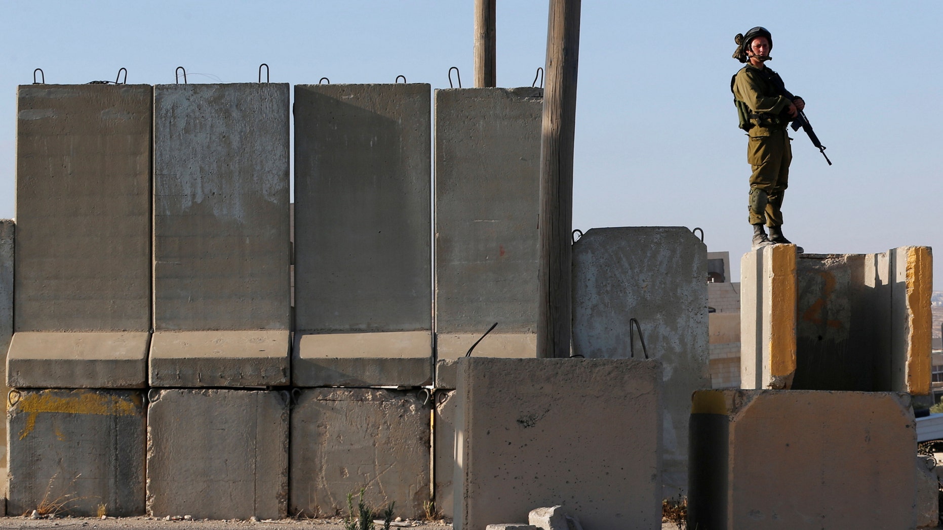 An Israeli soldier stands guard near the scene of an attempted stabbing attack by a Palestinian near Qalandiya checkpoint, near the West Bank city of Ramallah June 20, 2017. (REUTERS/ Ammar Awad)