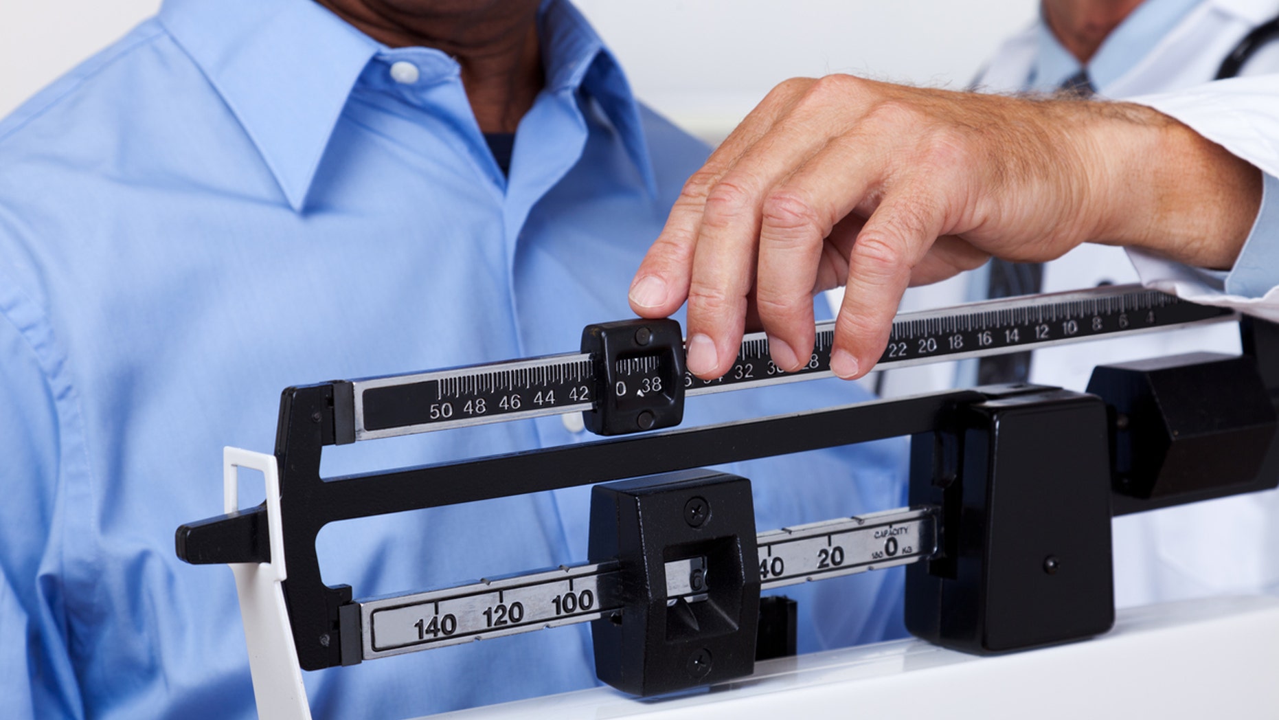 XXXL. Doctor checking weight of patient.