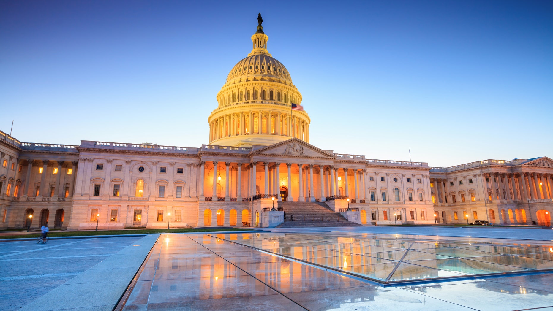 The United States Capitol building with the dome lit up at night.