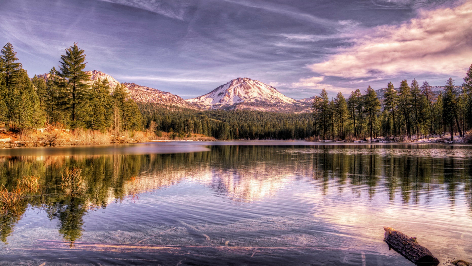 Lassen Peak, in the Lassen Volcanic National Park, shows signs of the first winter snow. In the foreground is Manzanita lake, which is a fly fisherman paradise.