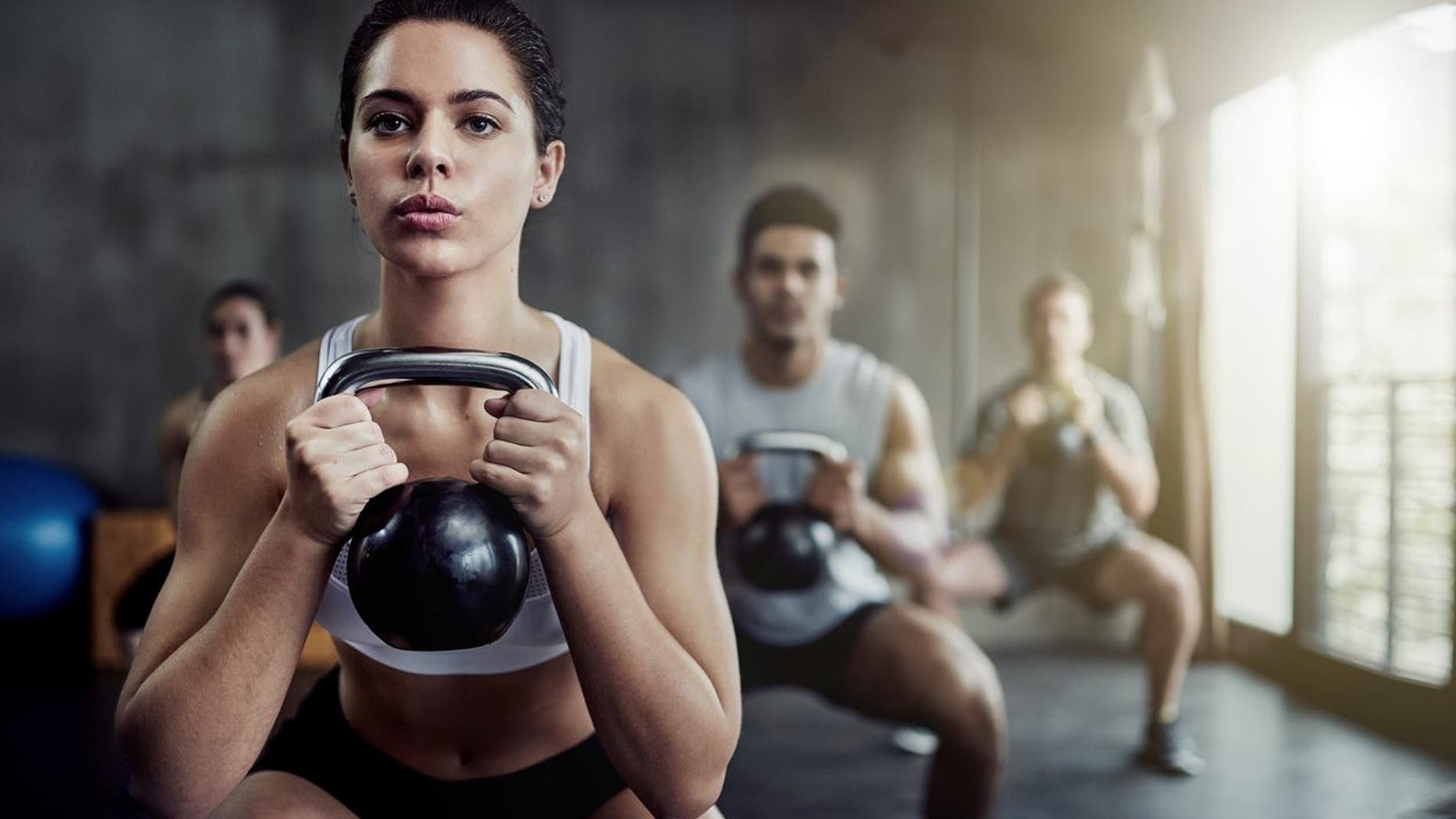 Shot of a fit young woman working out with a kettle bell at the gym