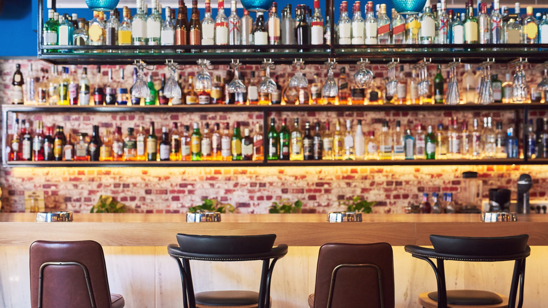 Shot of an immaculate bar with many bottles and glasses with no people