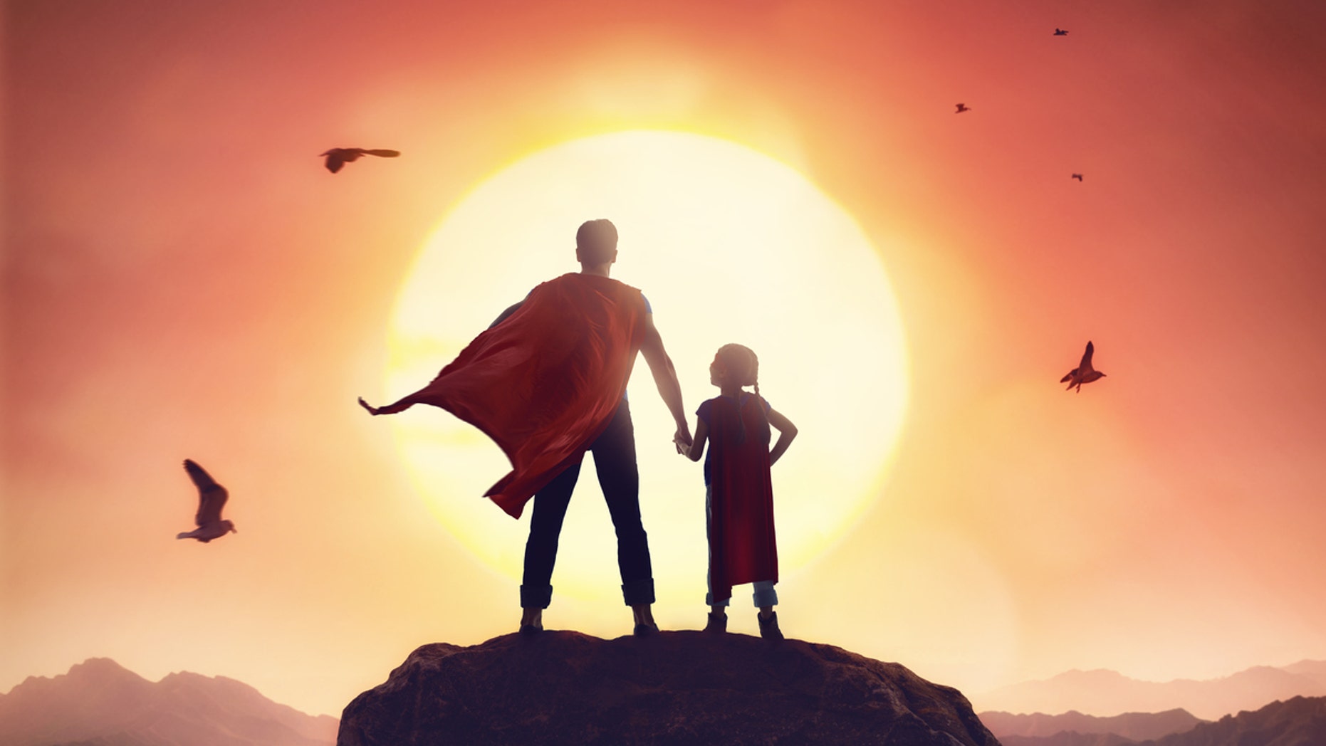 Happy loving family. Father and his daughter playing outdoors. Daddy and his child girl in an Superhero's costumes.