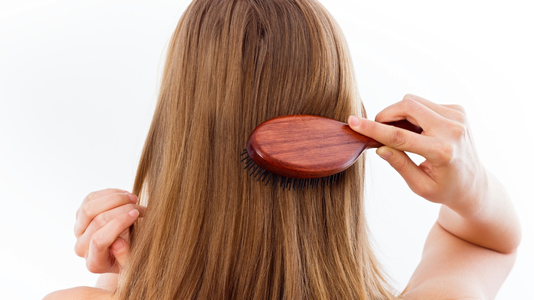 Woman combing her beautiful healthy hair.