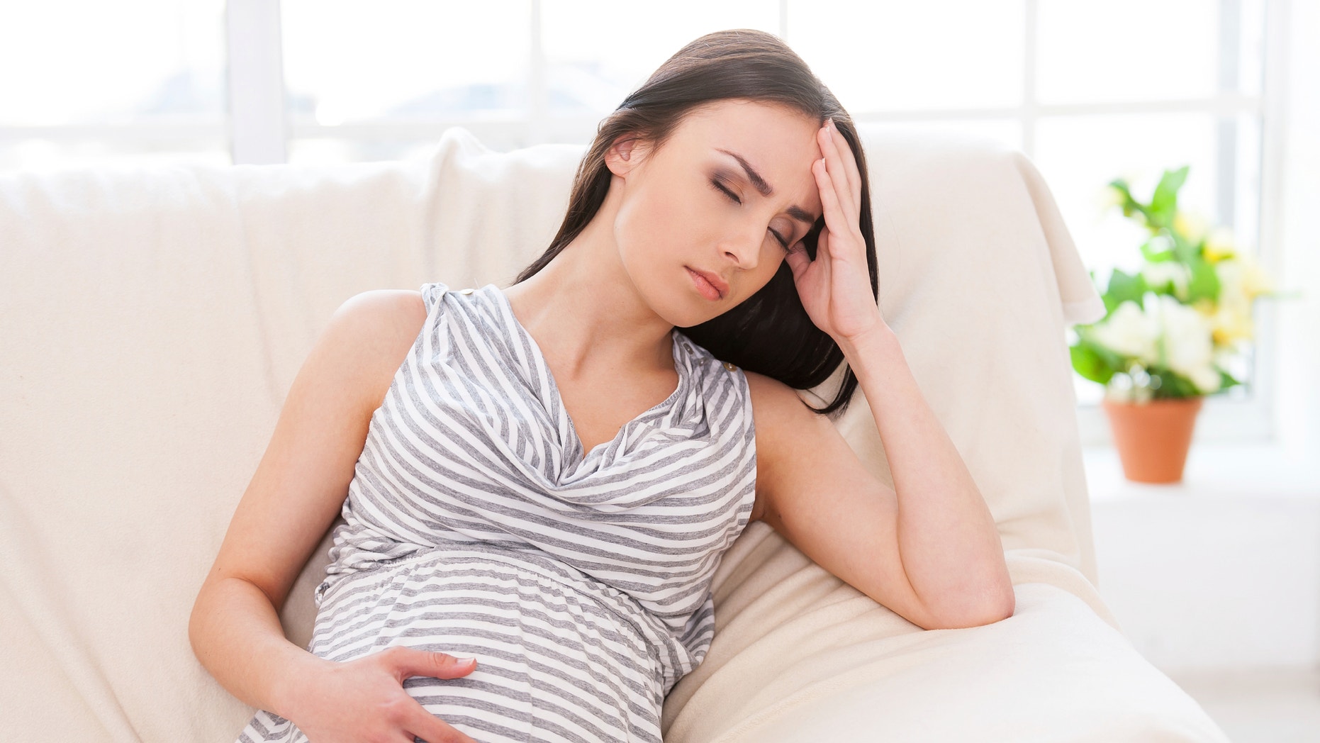 Struggling With Morning Sickness Depressed Pregnant Woman Holding Hand On Head And Keeping Eyes Closed