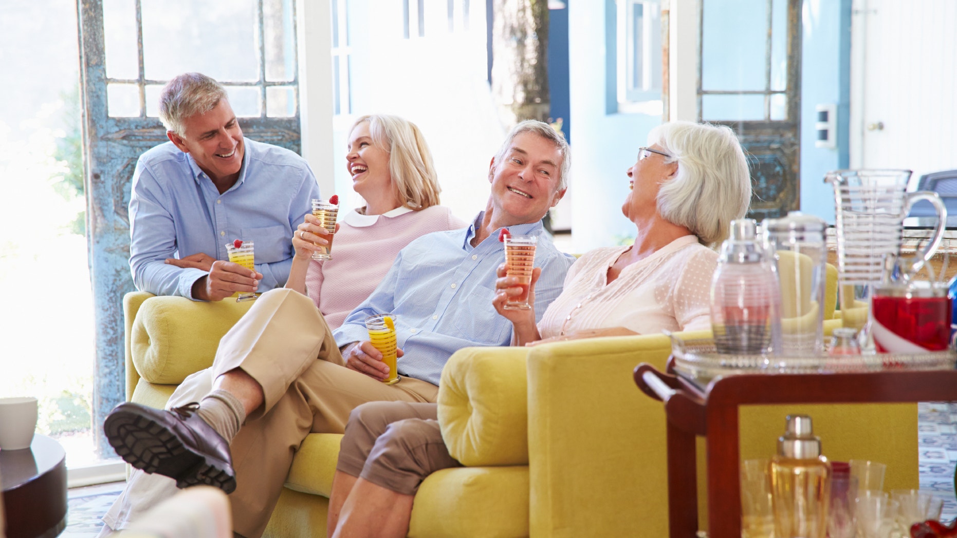 Group Of Friends At Home Relaxing In Lounge With Cold Drinks