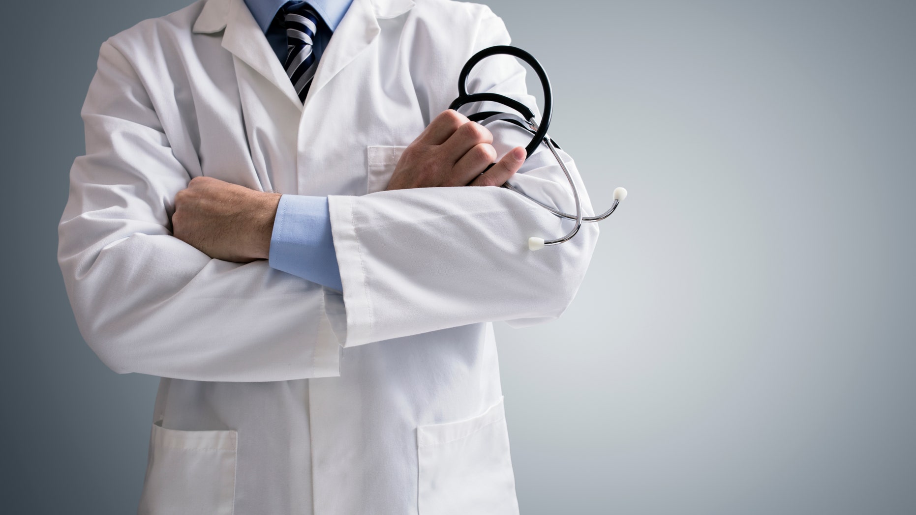 Doctor holding a stethoscope with arms crossed and copy space