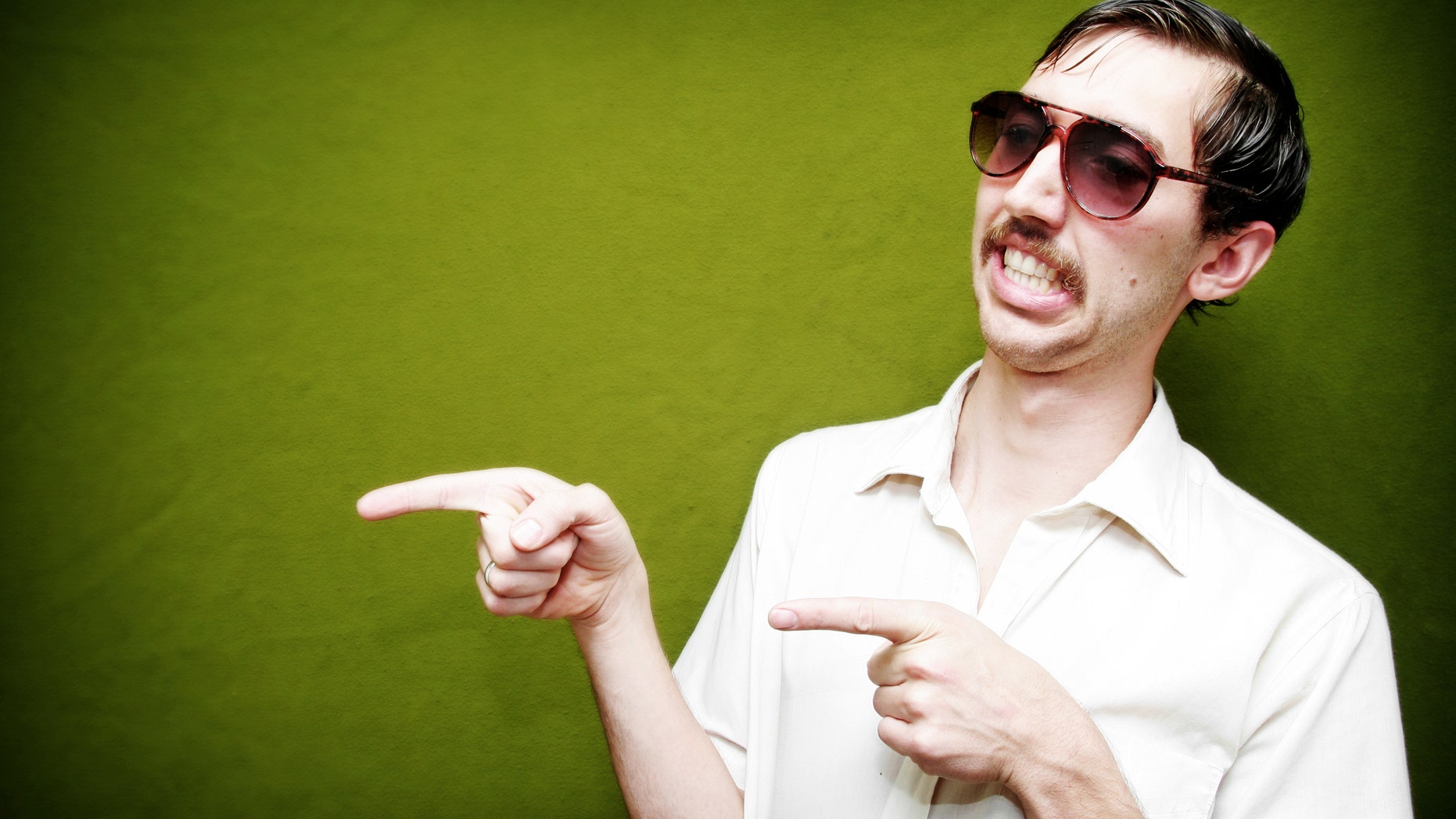 A salesman type points to at something / flirts with someone. Classy mustache and tinted sunglasses. Horizontal with copy space.