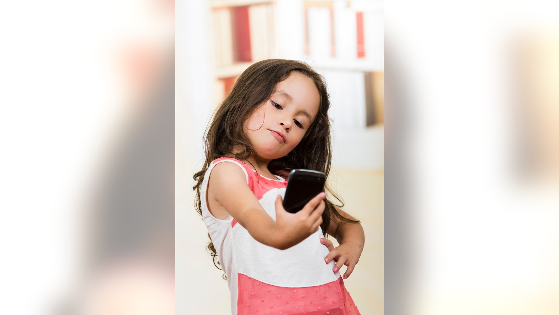 portrait of cute little happy using cell phone taking a selfie