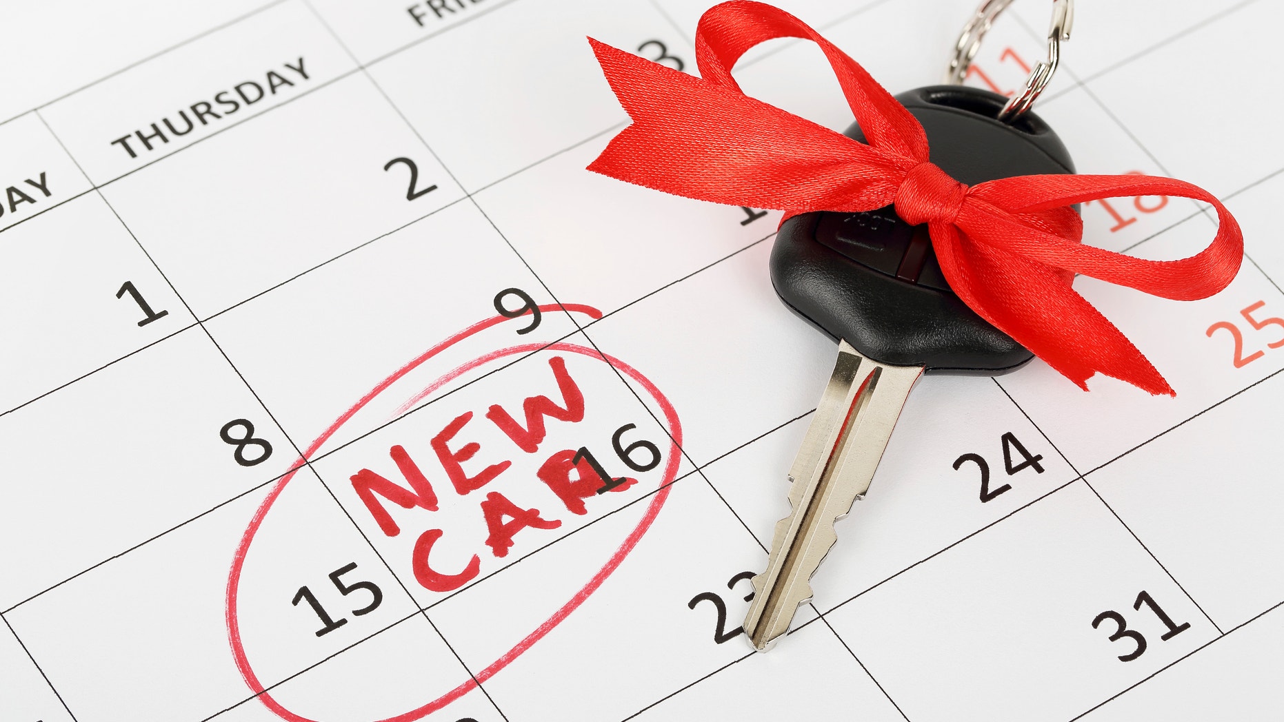 car key with ribbon on calendar, new car concept