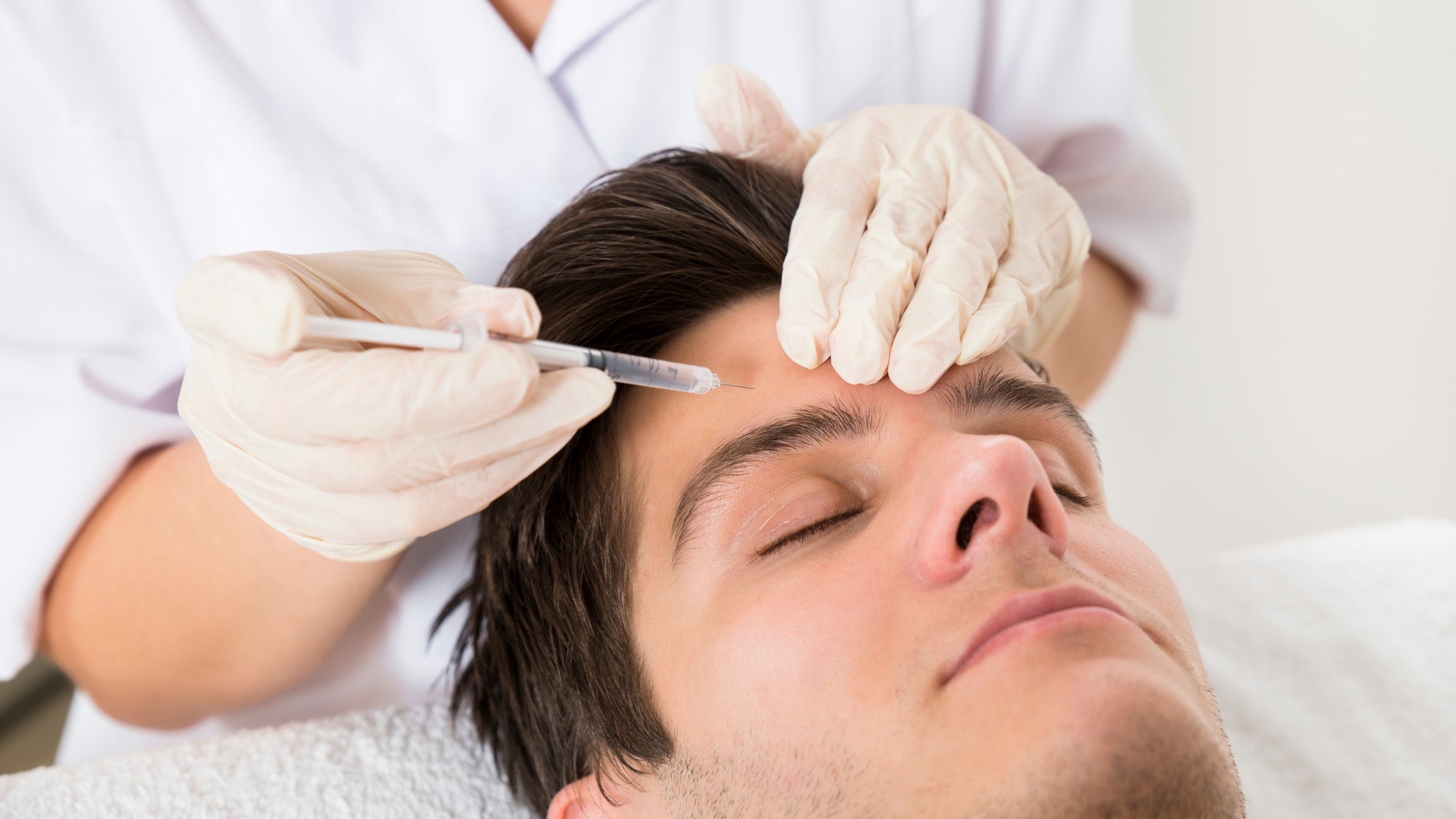 Young Man Having Botox Treatment At Beauty Clinic