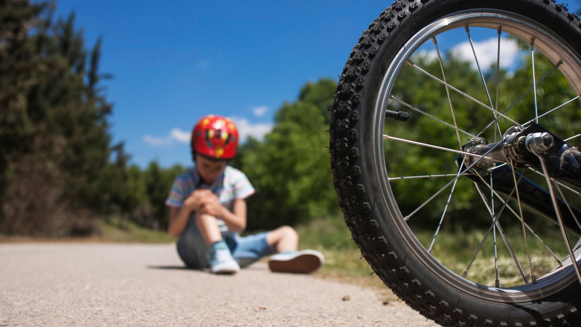 Boy is lying hurt after a bicycle accident. Kids safety concept