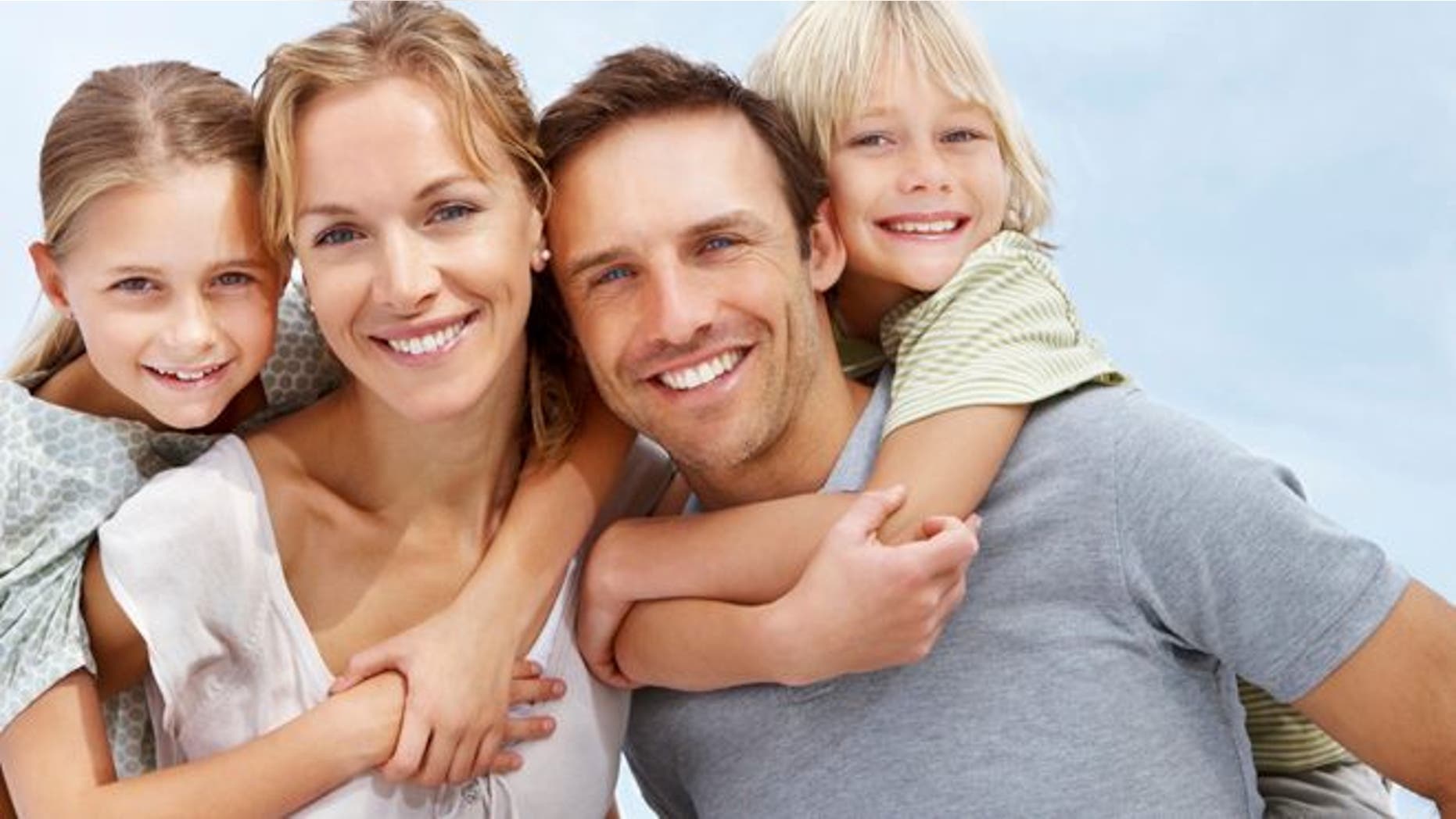 Portrait of a happy mature man and woman carrying kids on back