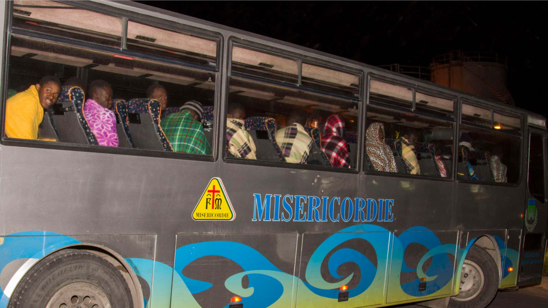 FEb. 9, 2015: Some of the migrants that were rescued at sea sit on a bus in the harbor of Lampedusa.