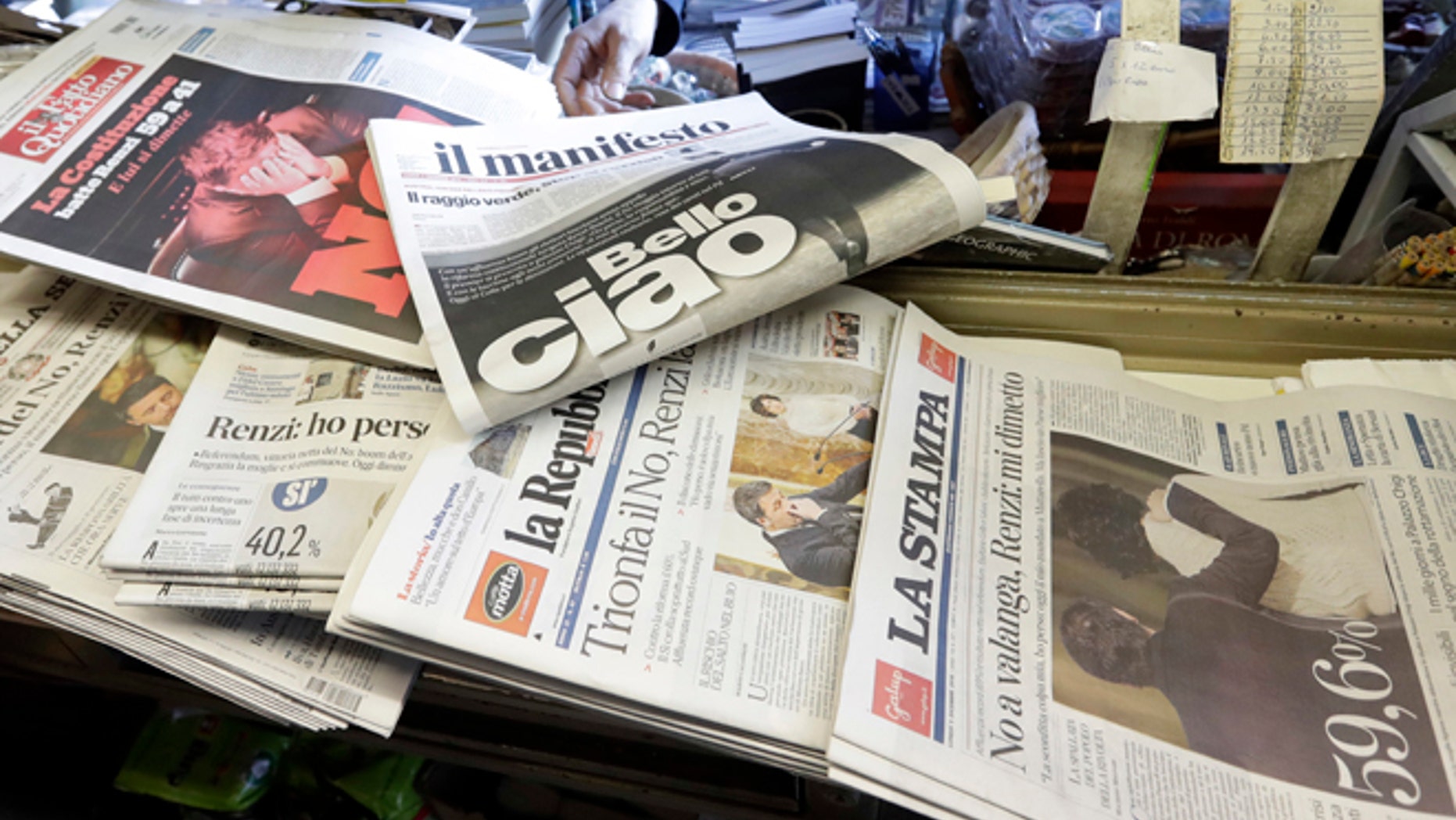Newspaper headlines show Italian Premier Matteo Renzi's resignation following the result of Sunday's constitutional referendum, at a newsstand in Rome, Monday, Dec. 5, 2016. Italian voters dealt Premier Renzi a resounding rebuke early Monday by rejecting his proposed constitutional reforms, plunging Europe's fourth-largest economy into political and economic uncertainty. (AP Photo/Gregorio Borgia)