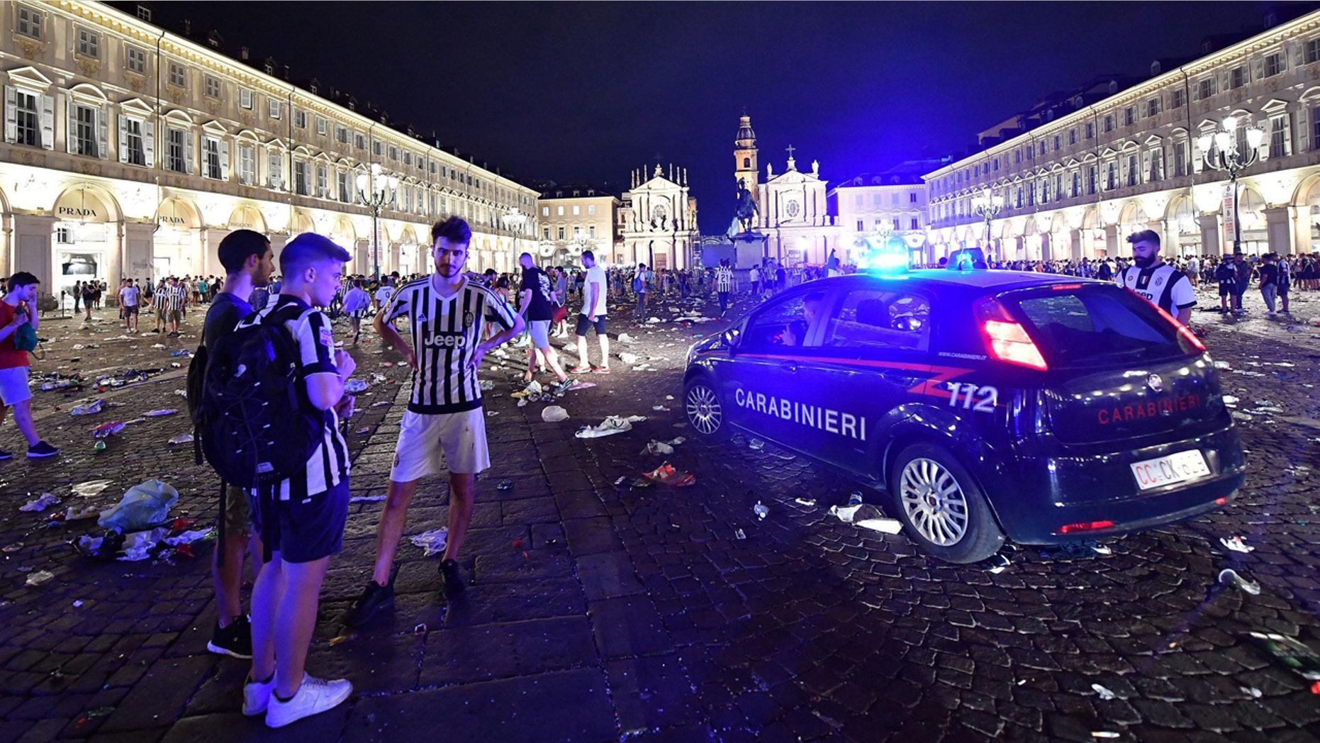 Juventus fans stand near a Carabinieri car, Italian paramilitary police, as they leave San Carlo's square at the end of the Champions League final soccer match between Juventus and Real Madrid, in Turin, Italy, Saturday, June 3, 2017