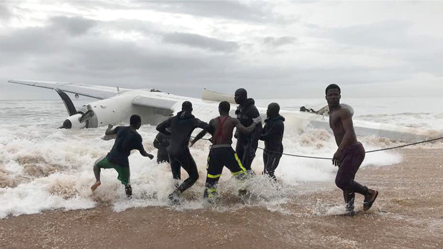 People pull the wreckage of a propeller-engine cargo plane after it crashed in the sea near the international airport in Ivory Coast's main city, Abidjan, October 14, 2017. REUTERS/Ange Aboa - RC197222A600