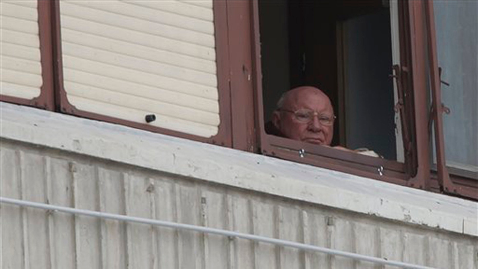 In this July 28, 2014, photo, Jakob Denzinger looks from his apartment window in Osijek, eastern Croatia. The suspected former Nazi prison guard at Auschwitz and other death camps, Jakob Denzinger, has died in his native Croatia at the age of 92. (AP Photo/Darko Bandic)