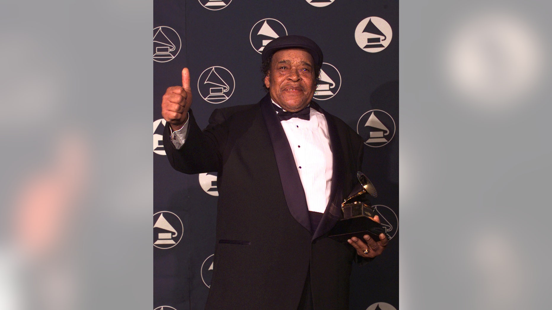 In this Feb. 26, 1997 file photo, blues musician James Cotton holds up a thumbs-up sign after winning the Best Traditional Blues Album during the pre-telecast program of the 39th Annual Grammy Awards in New York. Cotton won for his work "Deep In The Blues." Cotton, a Grammy Award-winning blues harmonica master whose full-throated sound backed such blues legends as Muddy Waters, Sonny Boy Williamson II and Howlin' Wolf, has died at age 81.