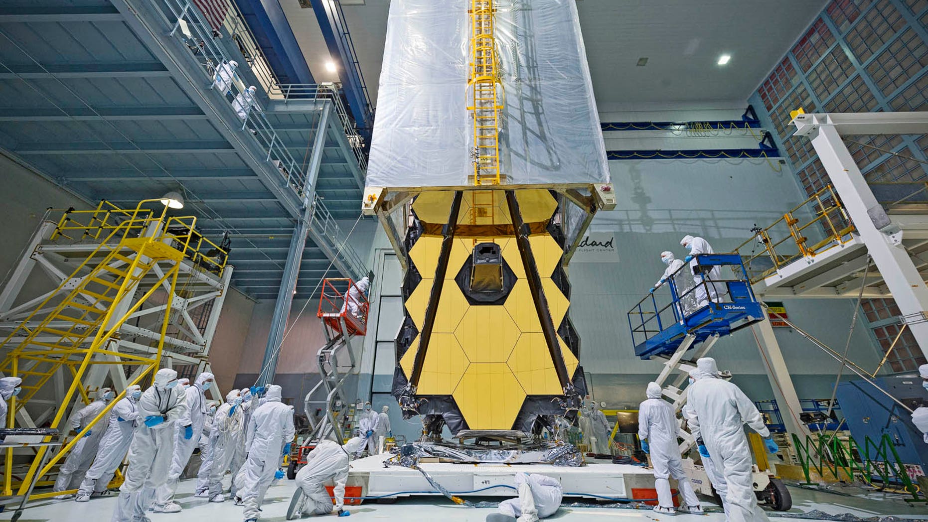 Engineers lower a clean tent over the James Webb Space Telescope during its assembly. NASA announced June 27 that the flagship space telscope's launch will be delayed to March 2021 due to ongoing technical problems.