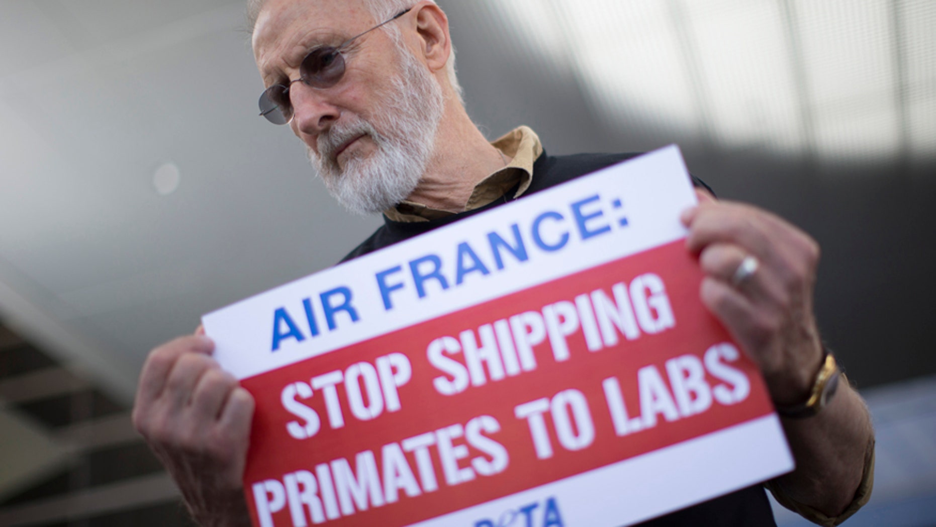 Actor James Cromwell holds a sign as he takes part in a PETA demonstration demanding Air France stop flying monkeys to laboratories, inside the Tom Bradley International Terminal at Los Angeles International Airport in Los Angeles, California April 28, 2014.