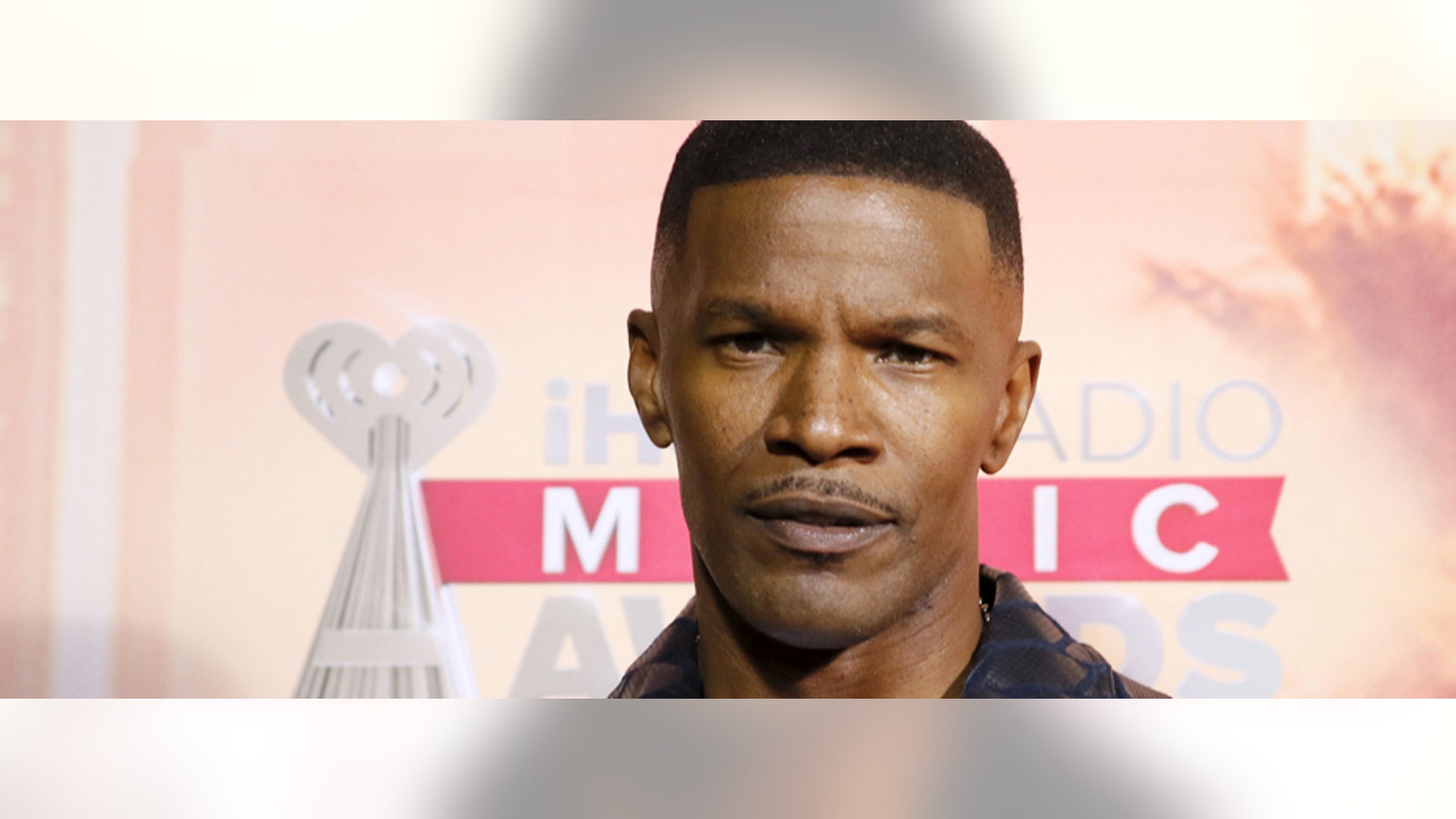 Actor and the evening's host Jamie Foxx makes a heart with his hands as he poses backstage at the 2015 iHeartRadio Music Awards in Los Angeles, California, March 29, 2015. REUTERS/Danny Moloshok - RTR4VEHG