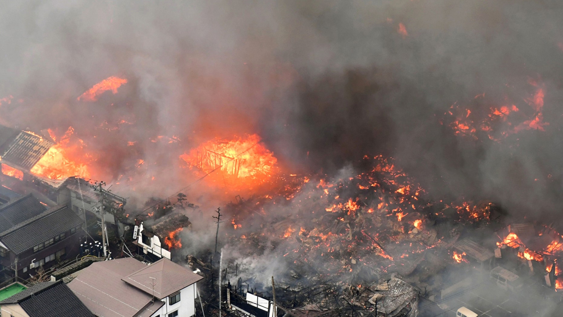 Smoke billow from houses during a fire in Itoigawa, northern Japan, Thursday, Dec. 22, 2016.