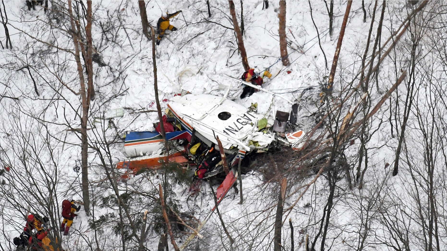 Rescuers work near the helicopter crashed in mountains in Nagano prefecture, central Japan Sunday, March 5, 2017. The rescue helicopter carrying nine people has crashed in snow-coved mountains during a training flight.
