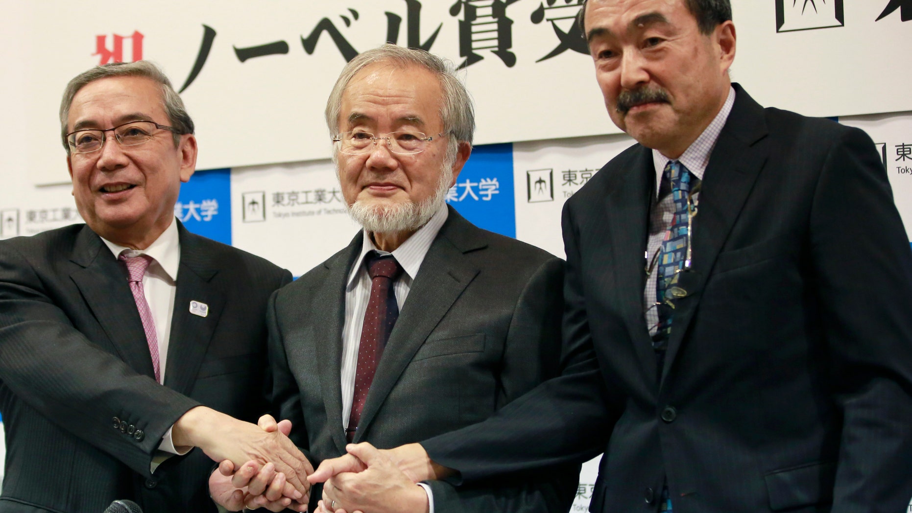 Nobel Prize winner Yoshinori Ohsumi, center, poses with Tokyo Institute of Technology President Yoshinao Mishima, left, and its Excutive Vice President Makoto Ando after a press conference at the Tokyo Institute of Technology in Tokyo Monday, Oct. 3, 2016. Ohsumi won the Nobel Prize in medicine on Monday for discoveries on how cells break down and recycle content, a garbage disposal system that scientists hope to harness in the fight against cancer, Alzheimerâs and other diseases