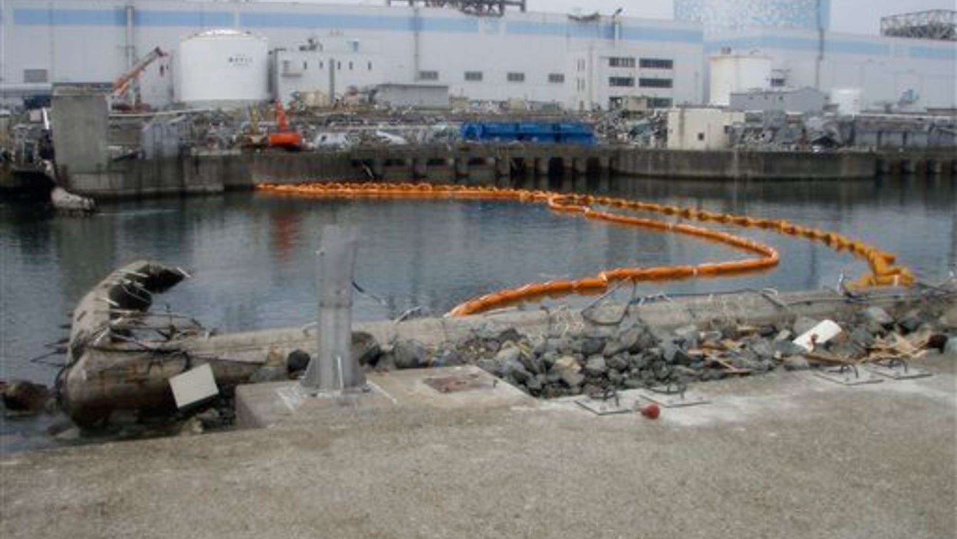 This Sunday, April 10, 2011 photo released by Tokyo Electric Power Co. (TEPCO) shows orange colored floats suspending a "silt fence" that was installed under water to help prevent contaminated water from spreading outside the Fukushima Dai-ichi nuclear power plant's bay. The tsunami-crippled nuclear complex is still leaking radiation after its cooling systems were knocked out by the March 11 tsunami (AP/TEPCO)